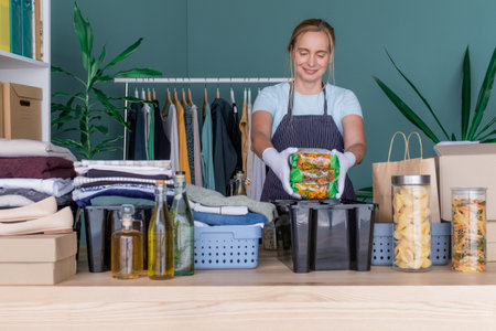 Woman packs in boxes clothes and products for charity and donation.の写真素材
