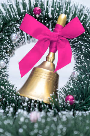 Gold bell with purple ribbon on the white background and Christmas tree eve New Yearの写真素材