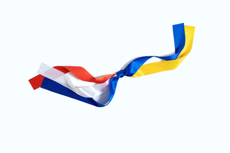Two flags Netherlands and Ukraine tied to a knot on the white background. The friendship and donation from the Netherlands to Ukraine during the Warの写真素材