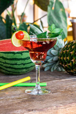 Cocktail Woowoo cherry, lime, mint, cranberry juice and vodka with watermelon and pineapple on the old wooden table.の写真素材