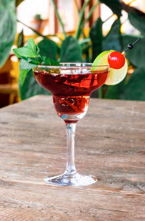 Cocktail Woowoo from cherry, lime, mint, cranberry juice and vodka stands on the old wooden table.の写真素材