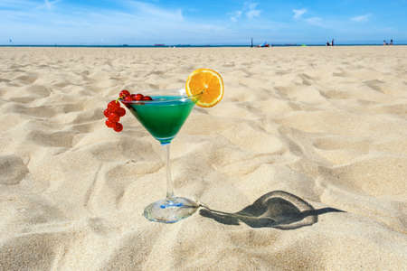 Cocktail Blue Curacao with melon liqueur, pineapple juice, currant and orange on the sand with light and shadow.の写真素材