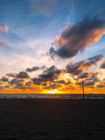 Sunset on the Beach of North sea, Scheveningen, The Hague, Netherlands. Blue Sky with Clouds and Ray of Sunの写真素材