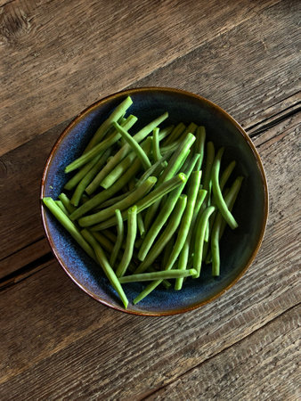 Green Beans in the Blue Plate, top view on the wooden table, healthy food.の写真素材