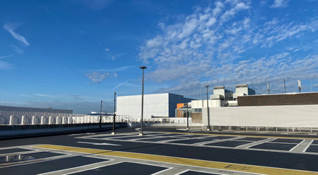 Modern urban parking in a big city with yellow markings and white houses and blue sky in sunny dayの写真素材