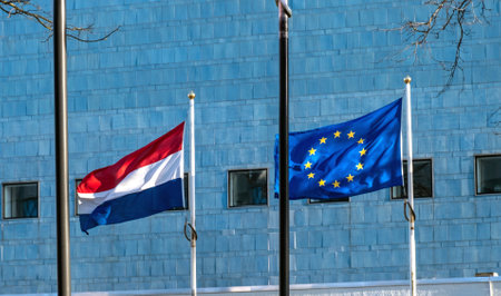 Two Flags Netherlands and European Union flutter in the wind next to the each other against the blue backgroundの写真素材