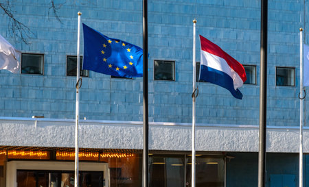 Two Flags Netherlands and European Union flutter in the wind next to the each other against the blue backgroundの写真素材