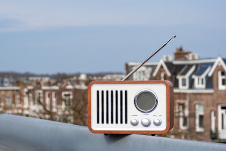 Old-fashioned vintage radio stands on the street against the backdrop of the sky and housesの写真素材