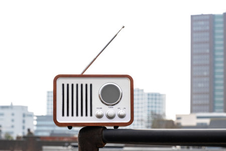 Old-fashioned vintage radio stands on the street against the backdrop of the sky and housesの写真素材