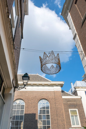 Crown of King on the blue sky background and old city center with old Hollands building.の写真素材