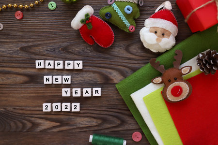 DIY Christmas crafting handmade crafts for new year.Felt santa, mittens, deer, gift box, thread on wooden background. Top view with copy space for text. Christmas DIY decorations.の写真素材