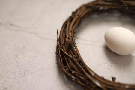 White chicken eggs in a nest on gray stone background. Top view. Free space. Easter eggs. High...