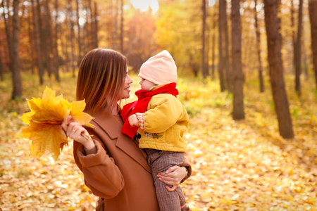 Mother and daughter having fun in autumn park. Happy family on walk. High quality photoの写真素材
