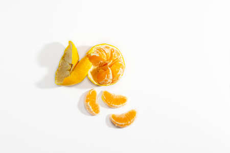 Half peeled tangerine and three tangerine wedges on a white background. Isolate. Life style. Clos ap. Horizontal photo.の写真素材