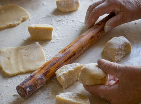 dough and flour on the table. cooking gingerbread. knead the dough to make a pie. grandmother prepares a cupcake. mom makes sweets.の写真素材
