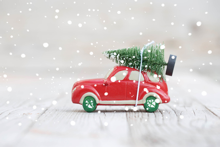 Miniature red car with fir tree on wooden background. Shallow DOFの写真素材