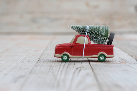 Miniature red car with fir tree on wooden background. Shallow DOFの写真素材