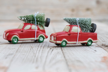 Miniature red car with fir tree on wooden background. Shallow DOFの写真素材