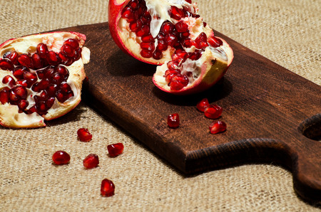 Pomegranate and pomegranate seeds on the kitchen blackboarの写真素材