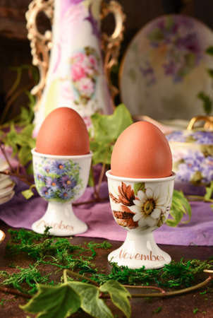 Boiled eggs on coasters in a composition on the table, breakfast in autumn.