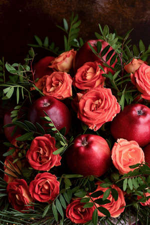 Autumn bouquet of roses and apples, dark photo, backgroundの写真素材