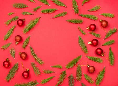 Christmas tree branches with christmas balls on a red background, holiday decorations, Christmas background, flatlay,の写真素材