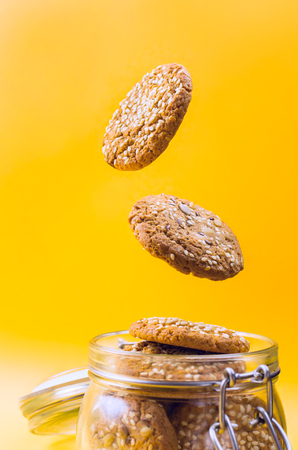 Cookies flying out of a glass jar. Selective focus.の写真素材