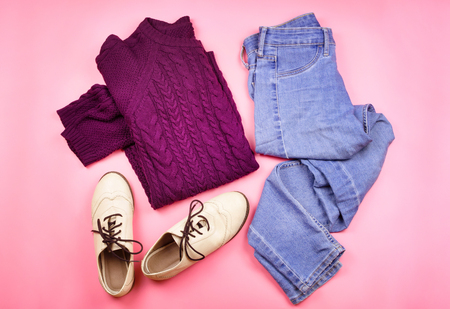 Flat lay of woman's autumn cozy clothes. Pink background.の写真素材