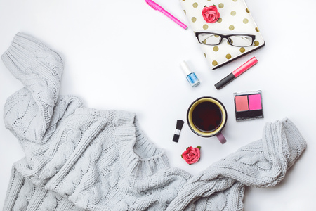 Beautiful flatlay with cozy sweater, Christmas lights and fashion accessories. Concept of cozy winter time. White background.の写真素材