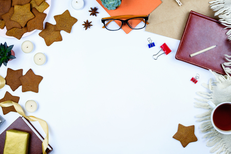 Beautiful flatlay with star-shaped cookies, glasses, cup of tea, notebook, cup of tea and other accessories. White background.の写真素材