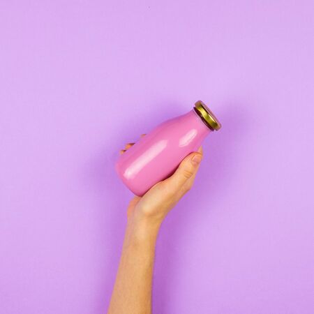 A bottle of juice or smoothie in a woman's hand. Concept of healthy food choice.の写真素材