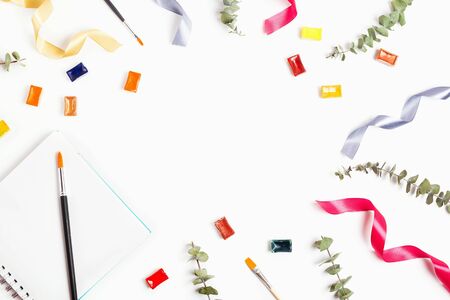 Beautiful background with dry eucalyptus, pan watercolors, ribbons and brushes, white background, copyspace. Creativity or education concept.の写真素材