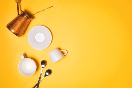 Turkish cezve, espresso cups and plate concept of coffee making and drinking. Yellow background, flatlay, copyspaceの写真素材