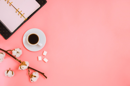 Flatlay with cup of espresso, cotton branch, sugar cubes and planner, business mockup, pink background, copyspaceの写真素材