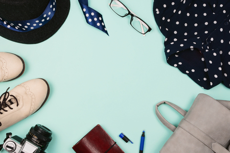 Beautiful fashion flatlay arrangement with female shoes, hat, glasses, backpack and camera. Mint background. Concept of holiday or travel preparation, spring clothes. Copyspace, fashion mockupの写真素材