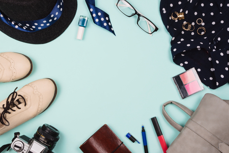 Beautiful fashion flatlay arrangement with various fashion accessories: glasses, cosmetics, jewelry, rings, shoes etc. Mint background. Concept of getting ready to go out. Copyspaceの写真素材