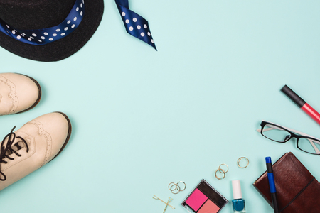 Beautiful fashion flatlay arrangement with various fashion accessories: glasses, cosmetics, jewelry, rings, shoes etc. Mint background. Concept of getting ready to go out. Copyspaceの写真素材