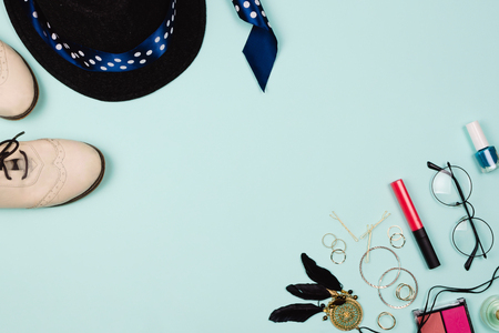 Beautiful fashion flatlay arrangement with various fashion accessories: glasses, cosmetics, jewelry, rings, shoes etc. Mint background. Concept of getting ready to go out. Copyspaceの写真素材