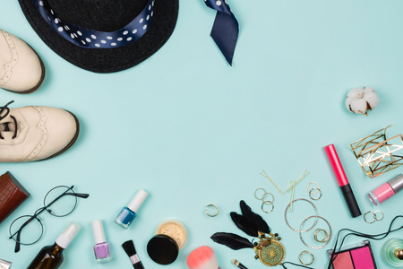 Beautiful fashion flatlay arrangement with various fashion accessories: glasses, cosmetics, jewelry, rings, shoes etc. Mint background. Concept of preparation. Copyspaceの写真素材