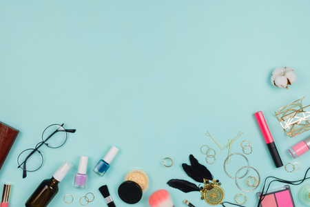 Beautiful fashion flatlay with various fashion accessories: glasses, cosmetics, jewelry, rings, etc. Copyspace, mint background, top viewの写真素材