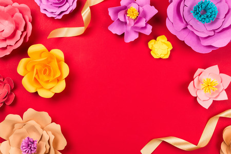 Beautiful floral spring or summer background. Papercraft flowers on red background, top view, flat lay, copyspaceの写真素材