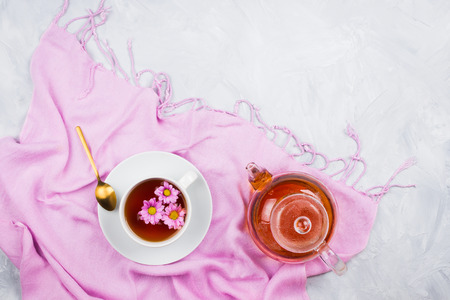 Glass kettle, teacup with tea on scarf, cement backgroundの写真素材