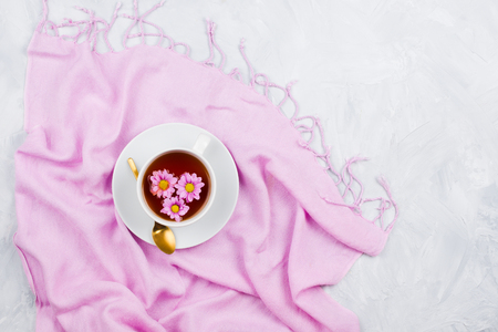 Cup of black tea on pink scarf, cement backgroundの写真素材