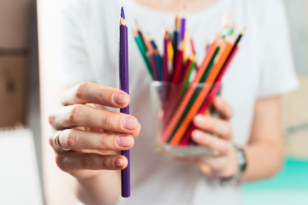Closeup of woman holding colorful pencils, selective shallow focus.の写真素材