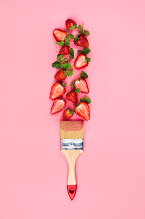 Wooden bristle painting brush with cut and whole strawberries and mint leaves on pink, strawberry sorbet ingredients, flatlayの写真素材