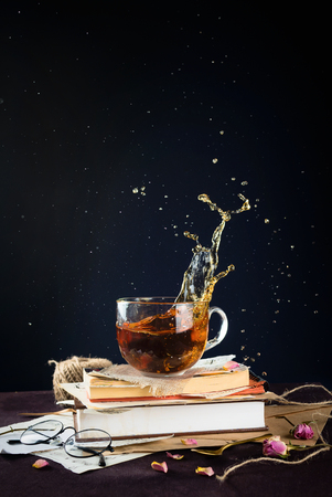 Splashing black tea on vintage books, selective focus, copyspaceの写真素材
