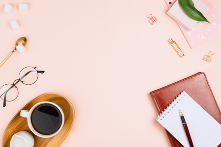 Business flatlay mockup with cup of coffee on a wooden tray, notebooks, glasses, spoon with sugar cubes and other accessories on pastel background with copyspaceの写真素材