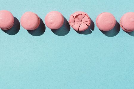 Pastel flatlay of pink vegan macaroons on pastel blue background