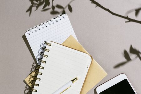 Minimalist flatlay with various notebooks, pen and smartphone wtih black copyspacescreen on grey backgroundの写真素材