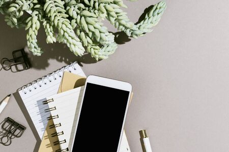 Minimalist flatlay with various notebooks, pen and smartphone wtih black copyspacescreen on grey backgroundの写真素材